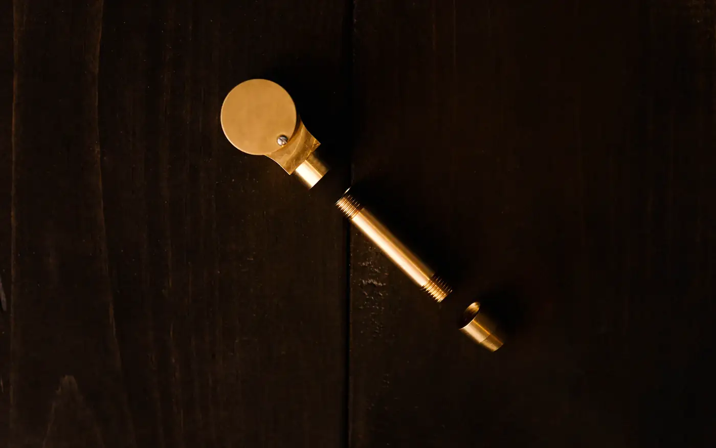 A single brass key on a dark wooden surface