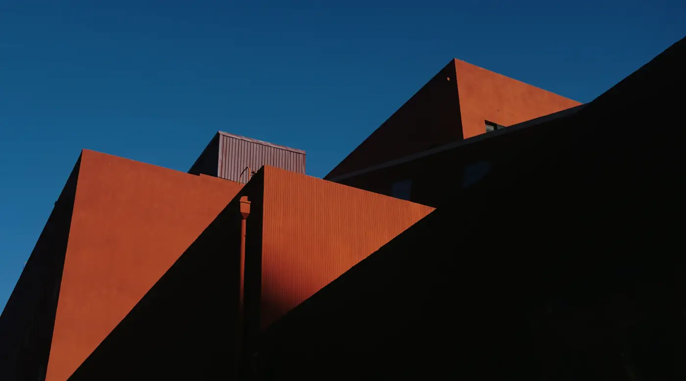 Sharp amber-coloured architectural shapes against a deep blue sky